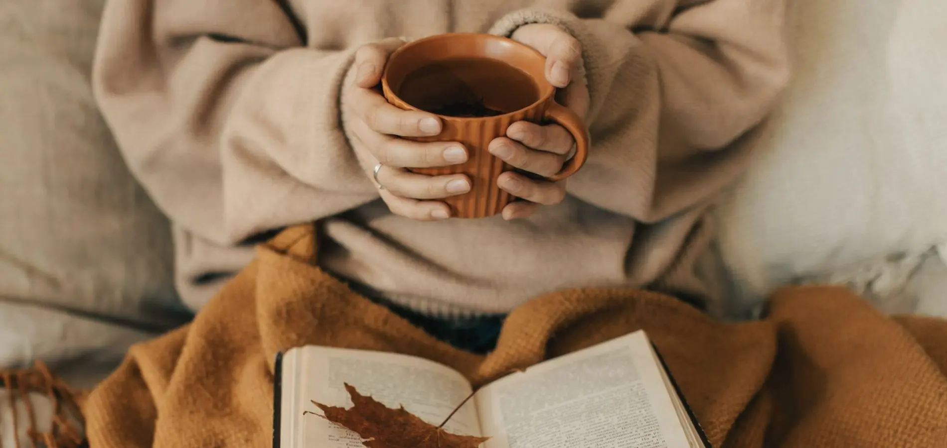 La photo de deux mains de femme tenant une tasse de thé, illustrant l’apaisement pour une désencombrement de sa maison sans stress